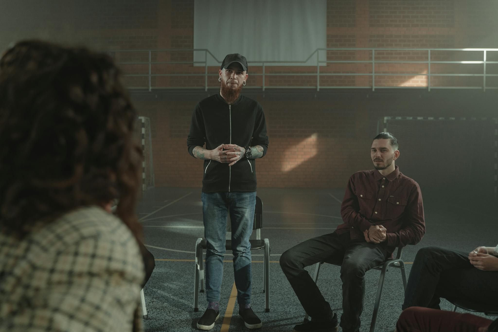 A group therapy session taking place indoors with diverse participants seated in a circle.